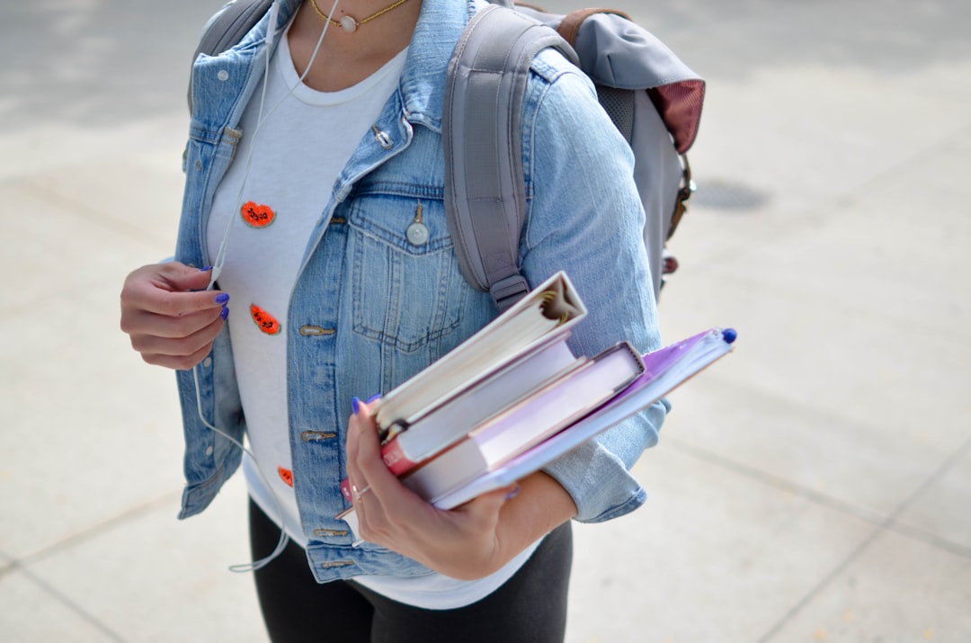 woman-wearing-blue-denim-jacket-holding-book-jcimcopfhig